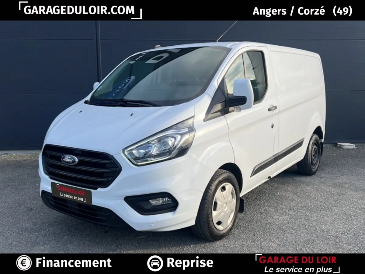 Vue 3/4 avant d'un Ford Transit Custom Fourgon blanc, avec calandre noire et feux avant LED visibles.