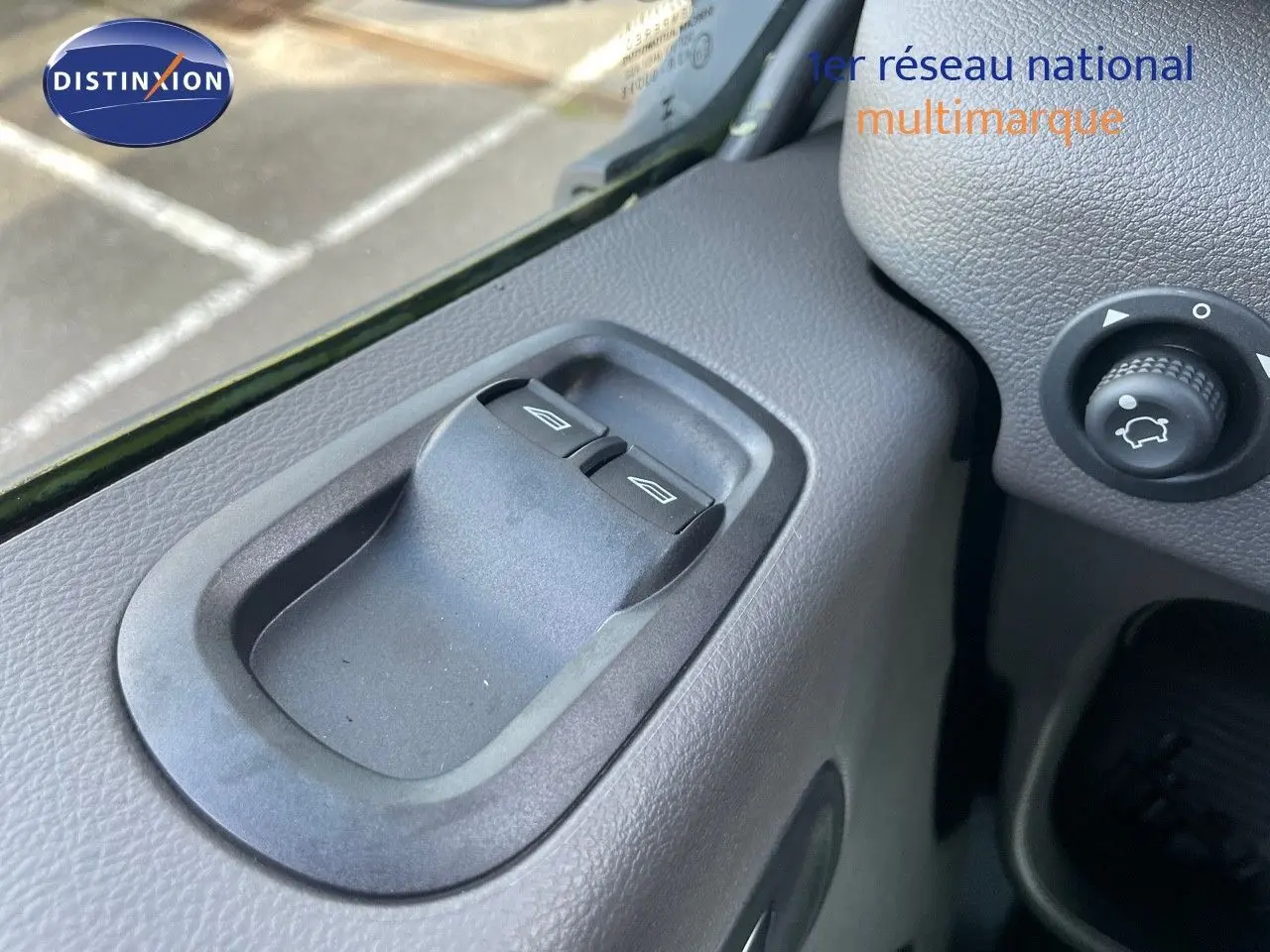 Gros plan sur les commandes des vitres côté gauche d'un Ford Transit Fourgon blanc 2023, intérieur gris.