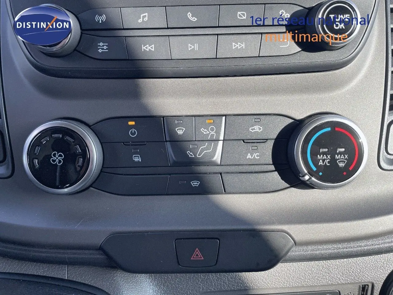 Gros plan sur la console centrale du Ford Transit Fourgon blanc 2023, montrant les commandes de climatisation et audio.