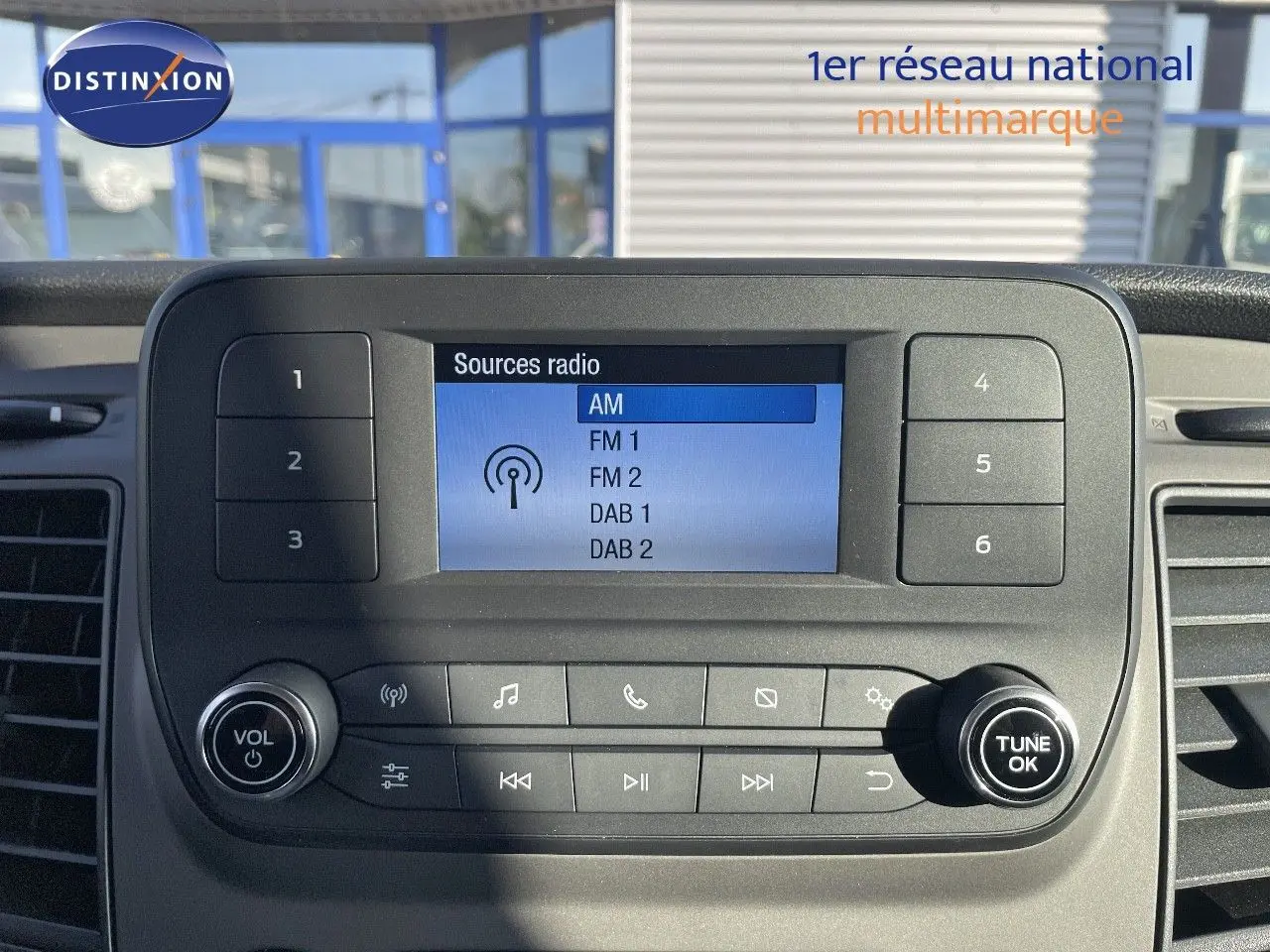 Écran central de la radio du Ford Transit Fourgon blanc 2023 affichant les sources AM, FM et DAB.