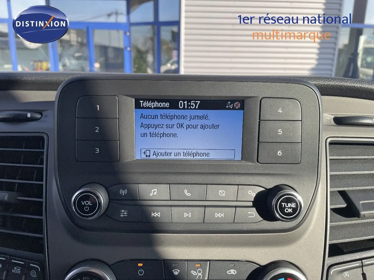 Vue rapprochée du tableau de bord du Ford Transit Fourgon 2023 avec écran central affichant l'ajout de téléphone.