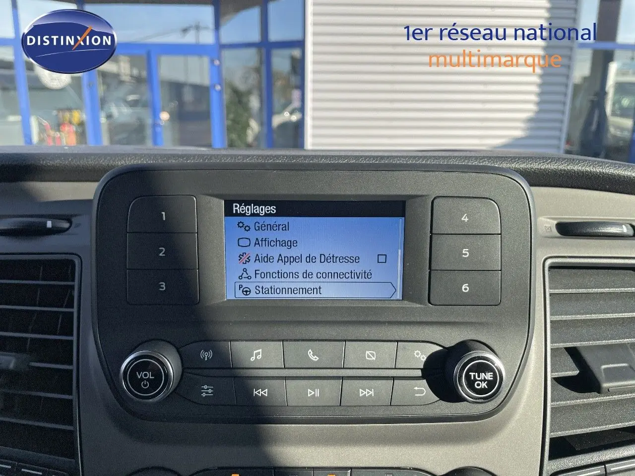 Écran central du tableau de bord du Ford Transit Fourgon blanc 2023 affichant les réglages de connectivité et stationnement.