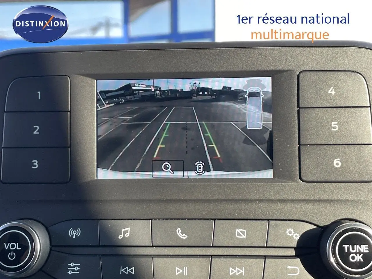 Écran de caméra de recul du Ford Transit Fourgon blanc 2023, affichant un parking vide vu de l'arrière.