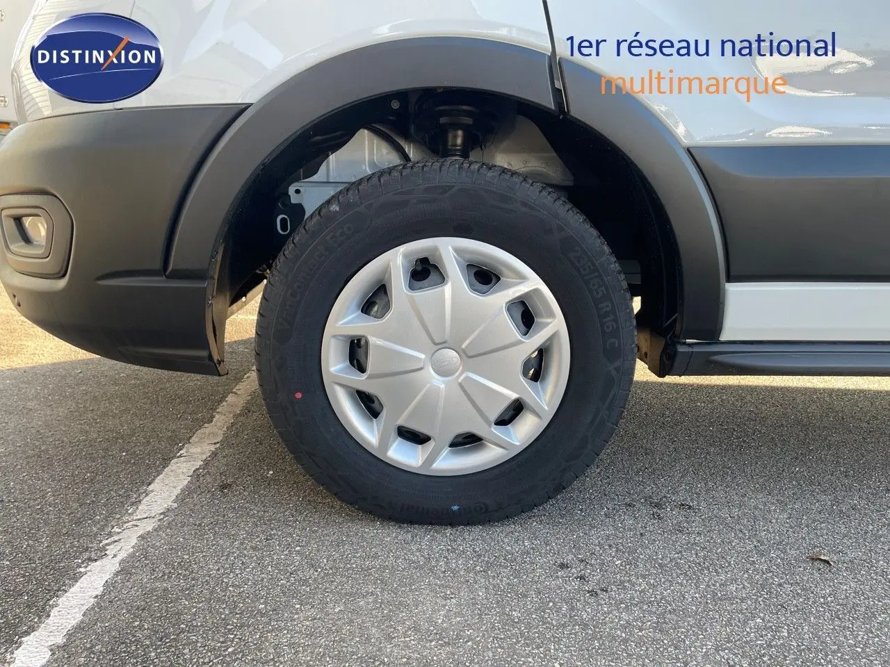 Gros plan sur la roue avant gauche du Ford Transit Fourgon blanc 2023, avec jante en plastique et pneus robustes.