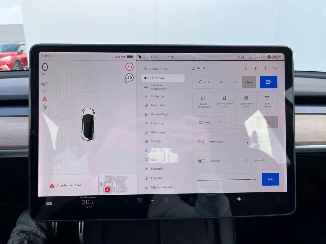Écran tactile central de la Tesla Model 3 blanc 2022, affichant les réglages de conduite et sécurité.
