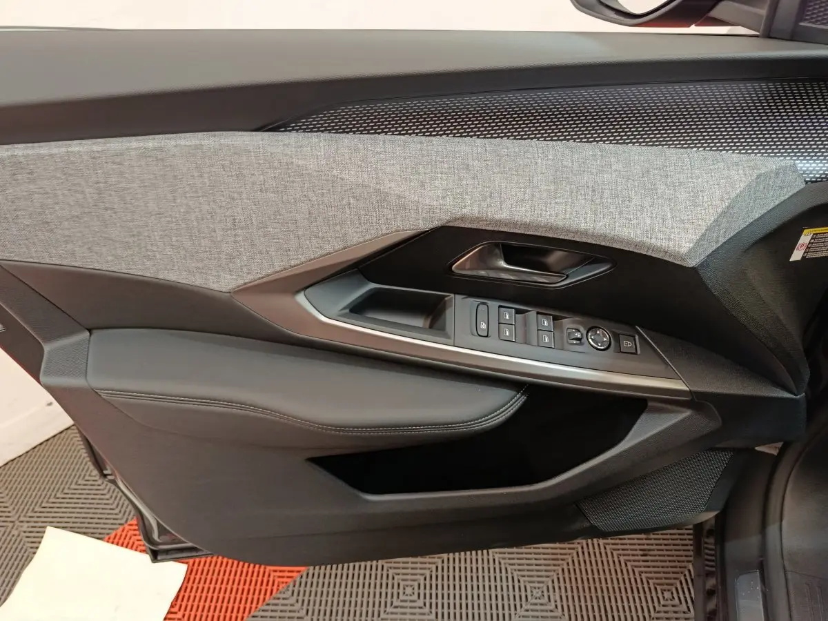 Porte côté gauche intérieur du Peugeot 3008 gris clair, avec commandes vitres et revêtement tissu gris et cuir noir.