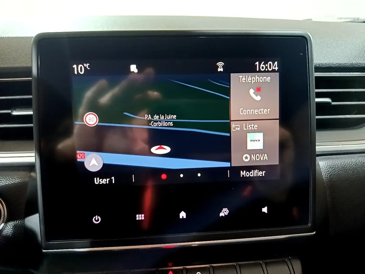 Écran tactile central du tableau de bord du Renault Captur Intens affichant la navigation et les options téléphone à 16h04.