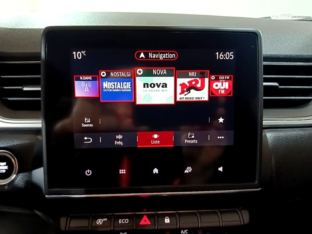 Écran tactile central du tableau de bord du Renault Captur Intens jaune, affichant les radios FM avec interface moderne.