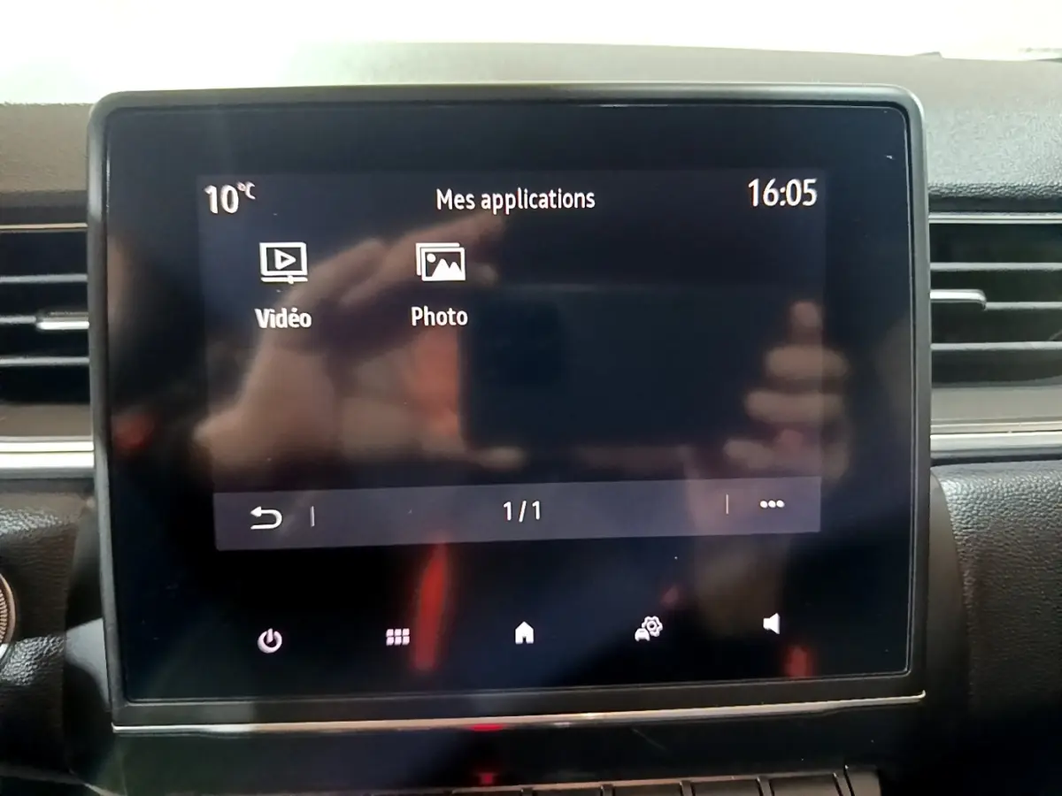 Écran tactile central du tableau de bord du Renault Captur Intens jaune, affichant les applications vidéo et photo.