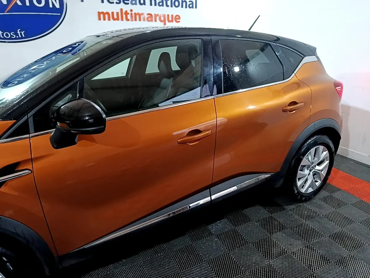 Vue de profil côté gauche d'un Renault Captur Intens jaune avec toit noir et jantes alliage.