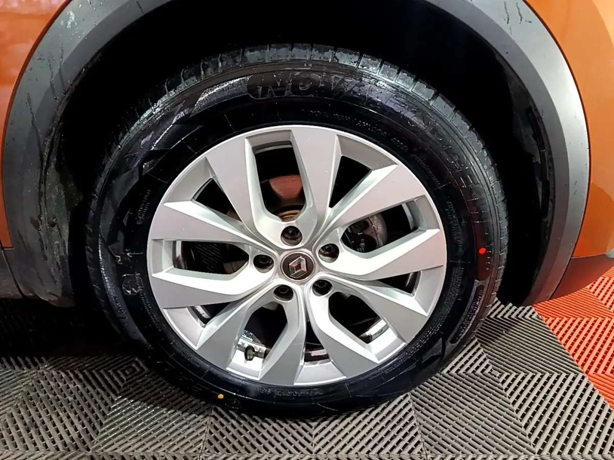 Gros plan sur la roue avant droite avec jante argentée du Renault Captur jaune 2020 Intens Blue dCi 115 EDC.