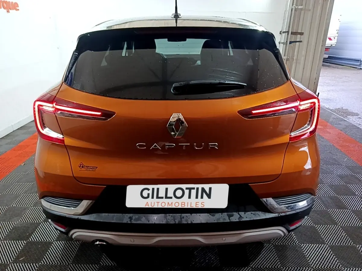 Vue arrière d'un Renault Captur jaune avec feux arrière LED allumés dans un garage.