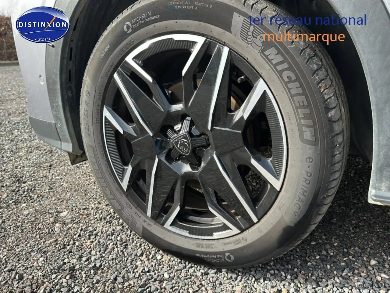 Gros plan sur la roue avant gauche du Peugeot 3008 gris Artense avec jante alu au design moderne.