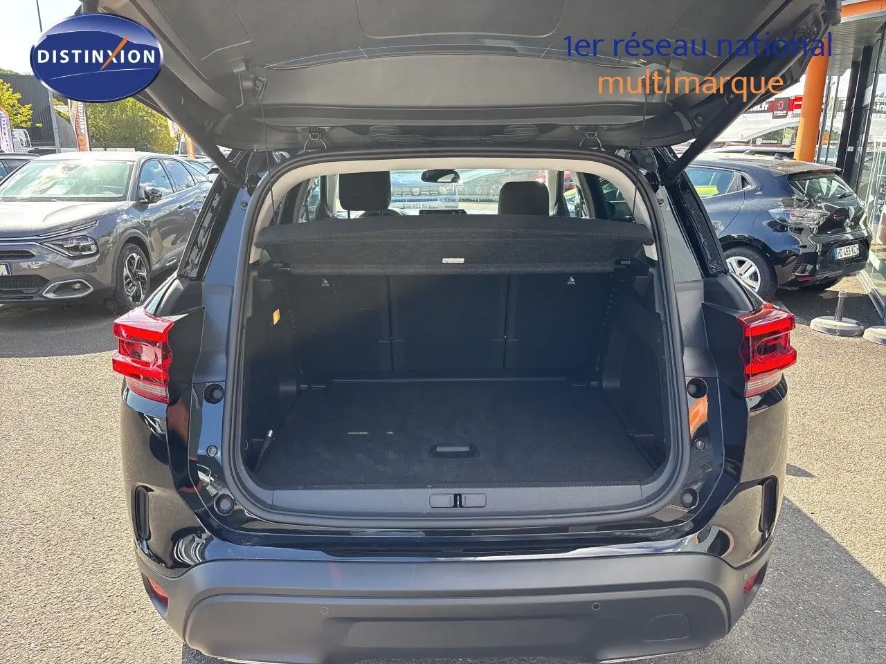 Coffre ouvert d’un Citroën C5 Aircross noir Perla Nera métal, vue arrière, montrant l’espace de chargement vide.