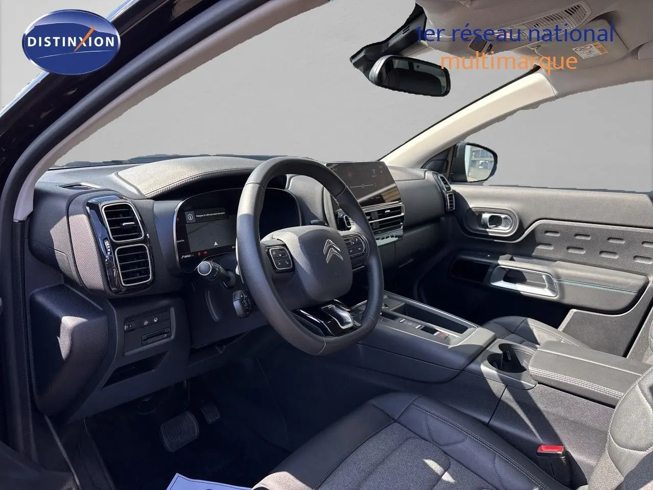 Intérieur noir du Citroën C5 Aircross 2025, vue côté conducteur, tableau de bord moderne avec écran tactile et volant multifonction.