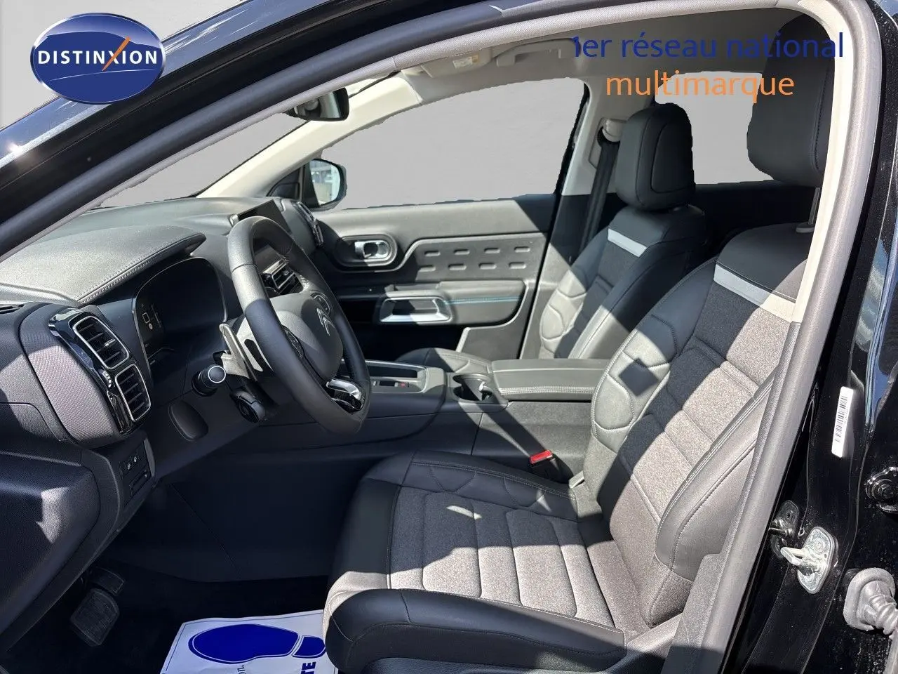 Vue intérieure côté conducteur du Citroën C5 Aircross noir Perla Nera, montrant sièges tissu et cuir et tableau de bord moderne.