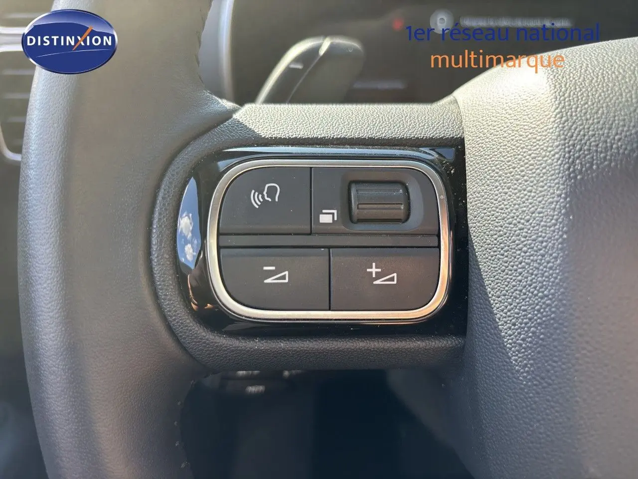 Gros plan sur les commandes gauche du volant du Citroën C5 Aircross 2025 noir Perla Nera, boutons de volume et appels.
