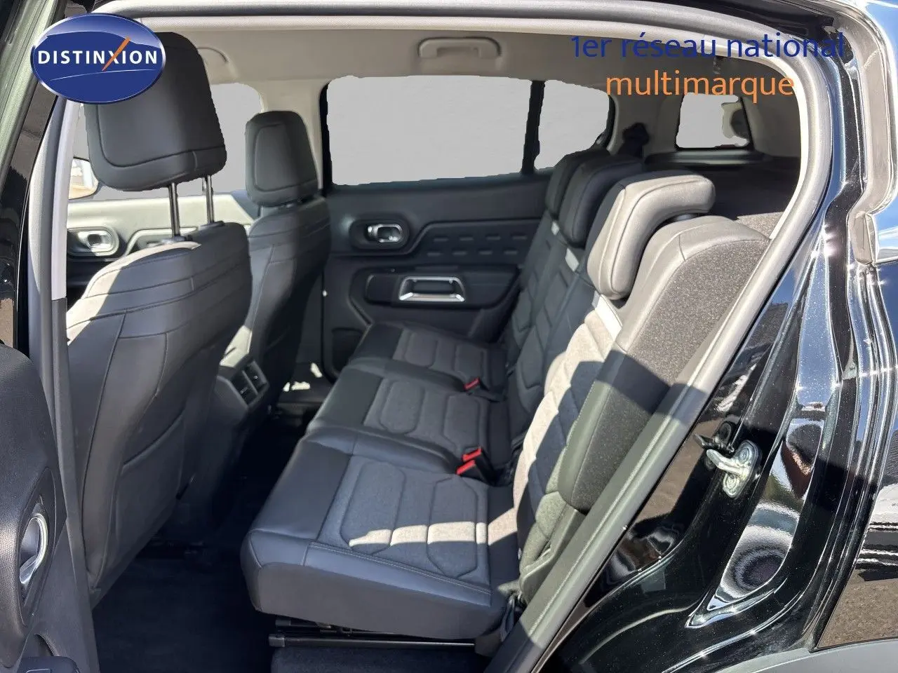 Vue intérieure côté droit montrant la banquette arrière en tissu et cuir du Citroën C5 Aircross noir Perla Nera 2025.
