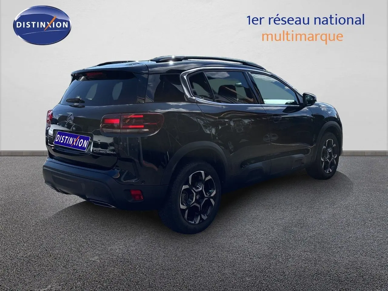 Vue 3/4 arrière droite d'un Citroën C5 Aircross noir Perla Nera métallisé avec jantes bi-ton et vitres teintées.