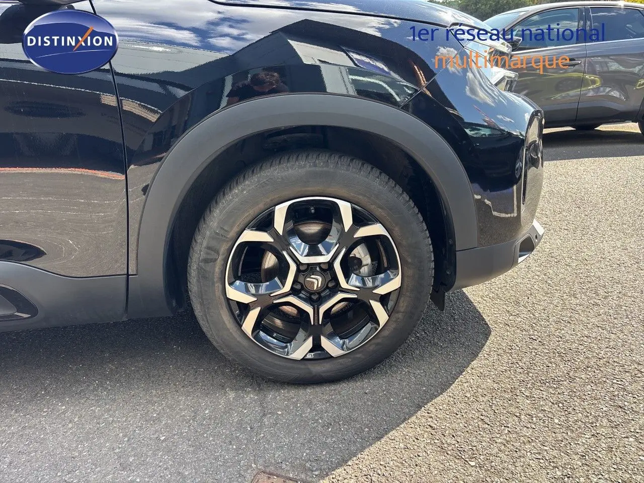 Gros plan sur la roue avant gauche d’un Citroën C5 Aircross noir Perla Nera avec jante alliage distinctive.