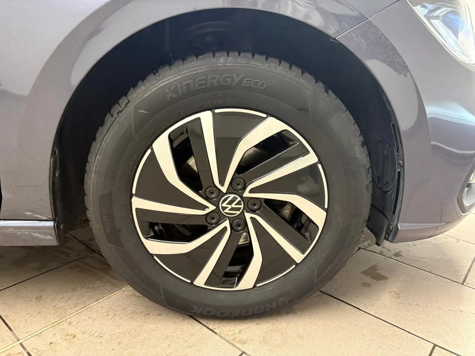 Gros plan sur la roue avant droite d'une Volkswagen Polo gris cendre 2024 avec jante alliage noire et argentée.