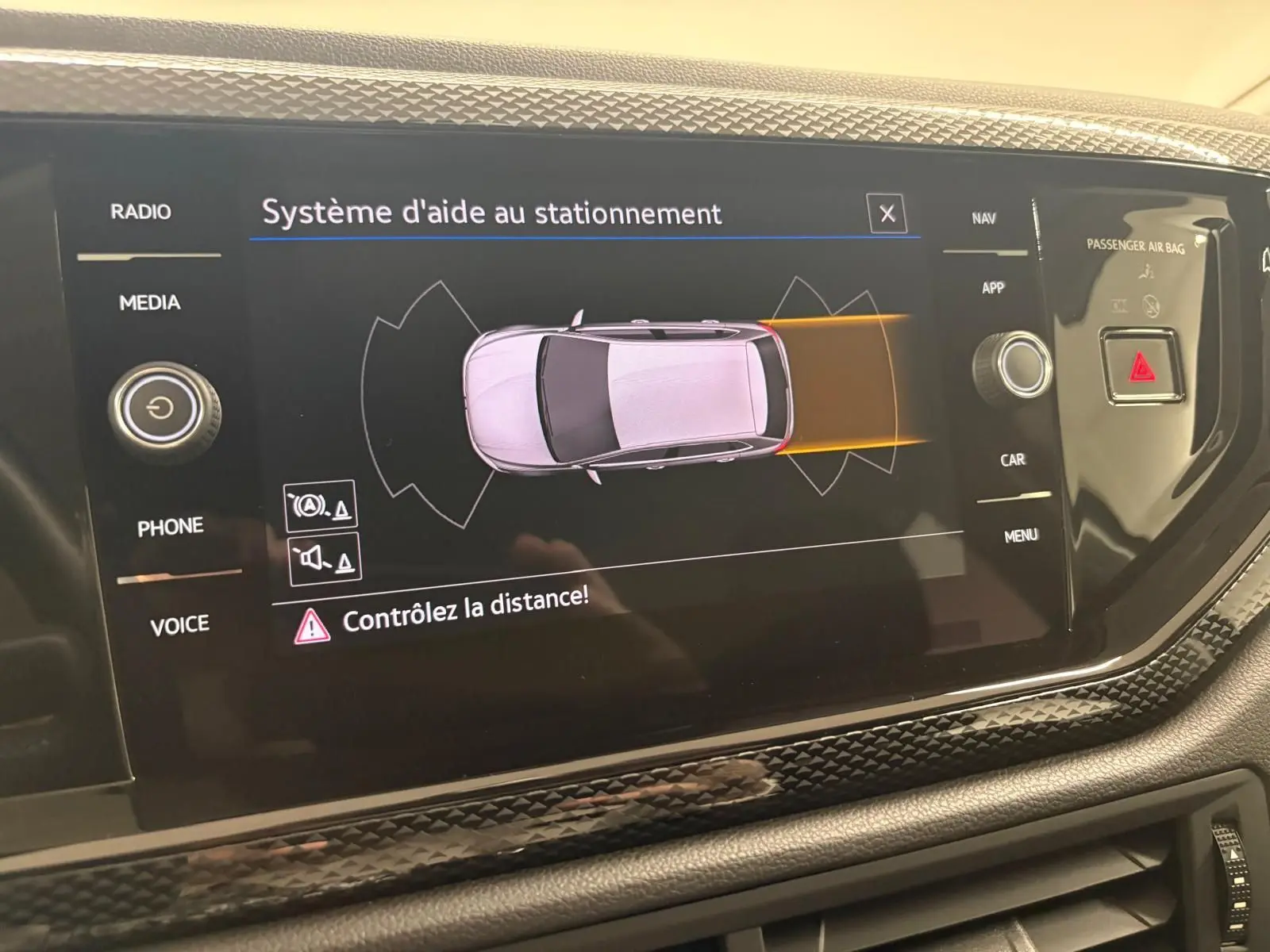 Écran central montrant le système d'aide au stationnement actif dans une Volkswagen Polo gris cendre 2024.