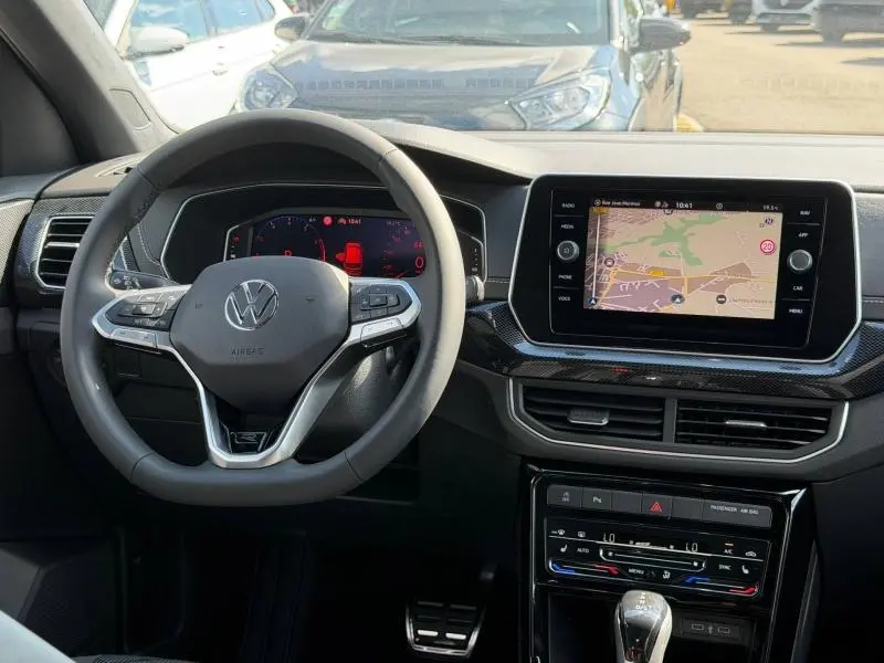 Vue intérieure centrée sur le volant cuir multifonction et l'écran tactile GPS du Volkswagen T-Cross 2026.
