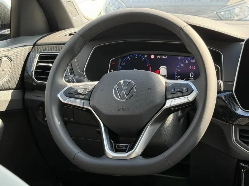 Vue frontale du volant cuir multifonction et tableau de bord numérique du Volkswagen T-Cross jaune 2026 R-Line.