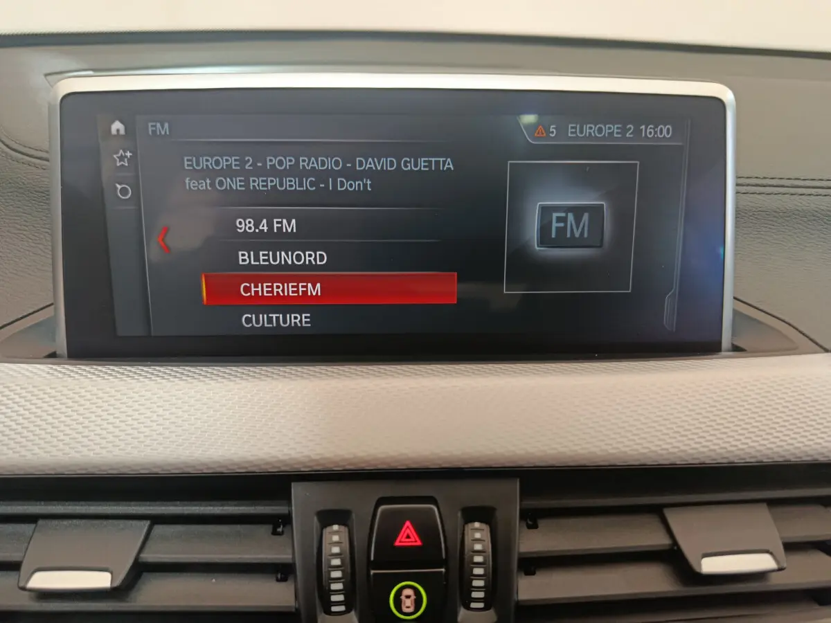 Écran tactile central affichant les stations radio dans l'habitacle d'une BMW X1 sDrive18i M Sport 2019.