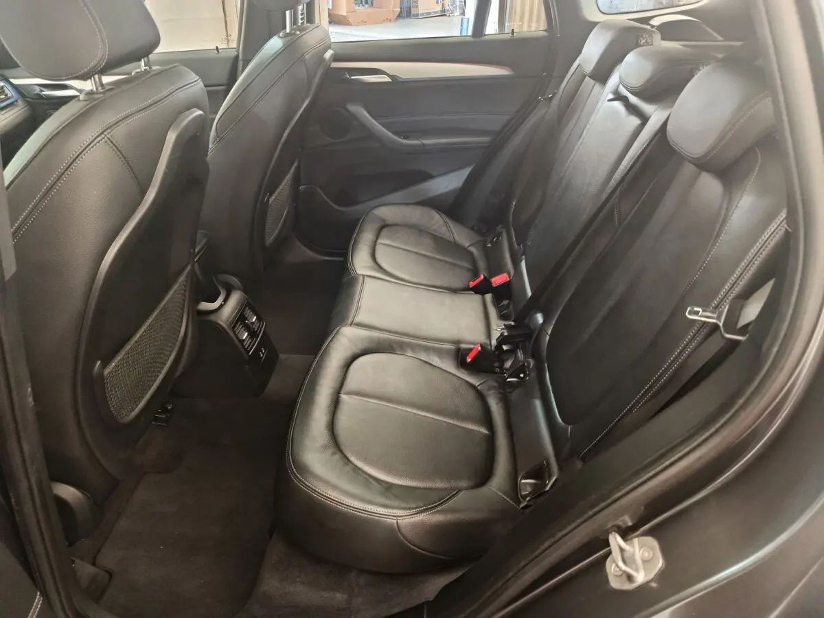 Vue côté droit de la banquette arrière cuir noir du BMW X1 sDrive18i M Sport 2019 avec finitions soignées.