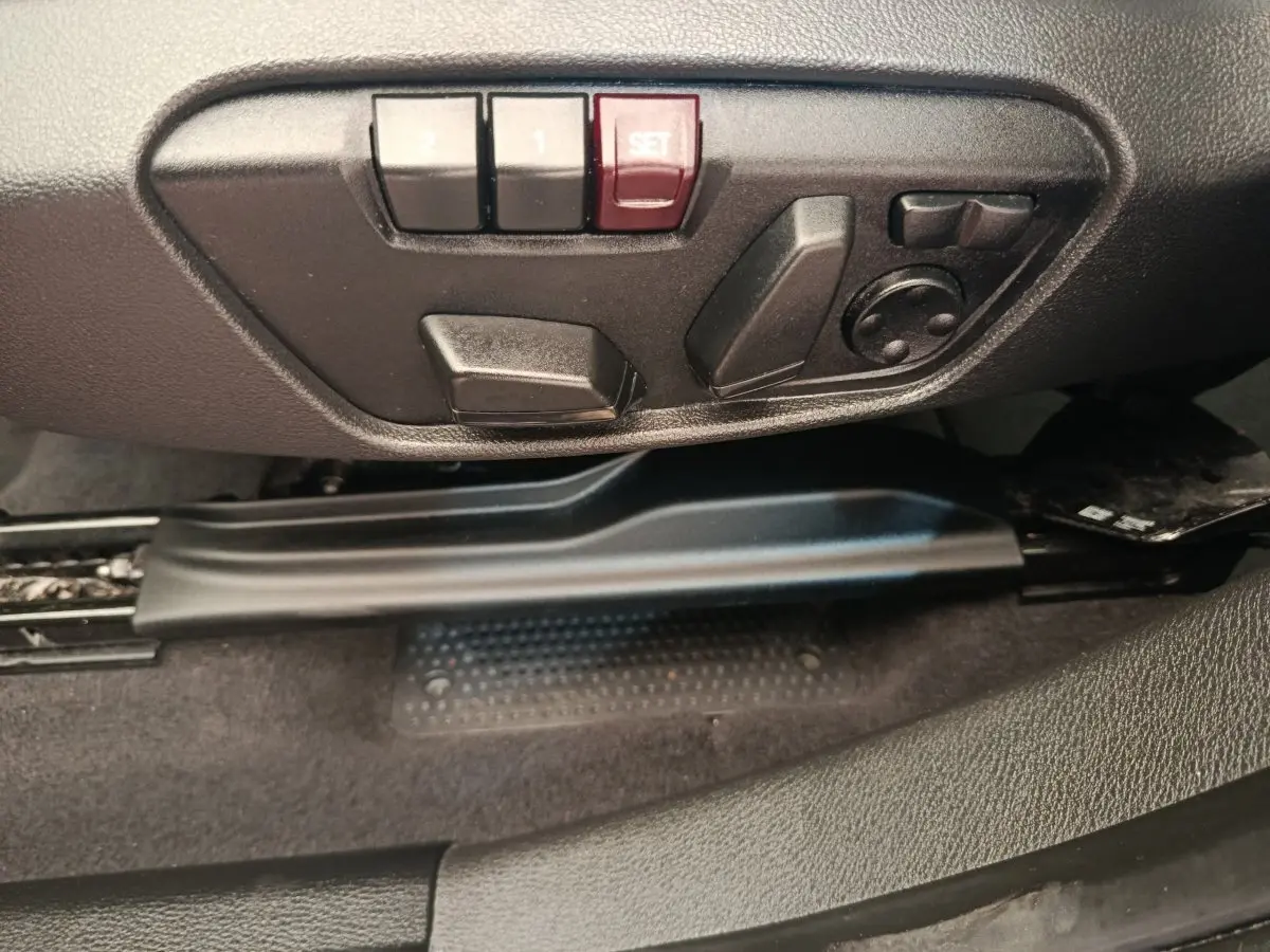 Gros plan sur les commandes de réglage électrique du siège côté conducteur d'un BMW X1 sDrive18i M Sport 2019.