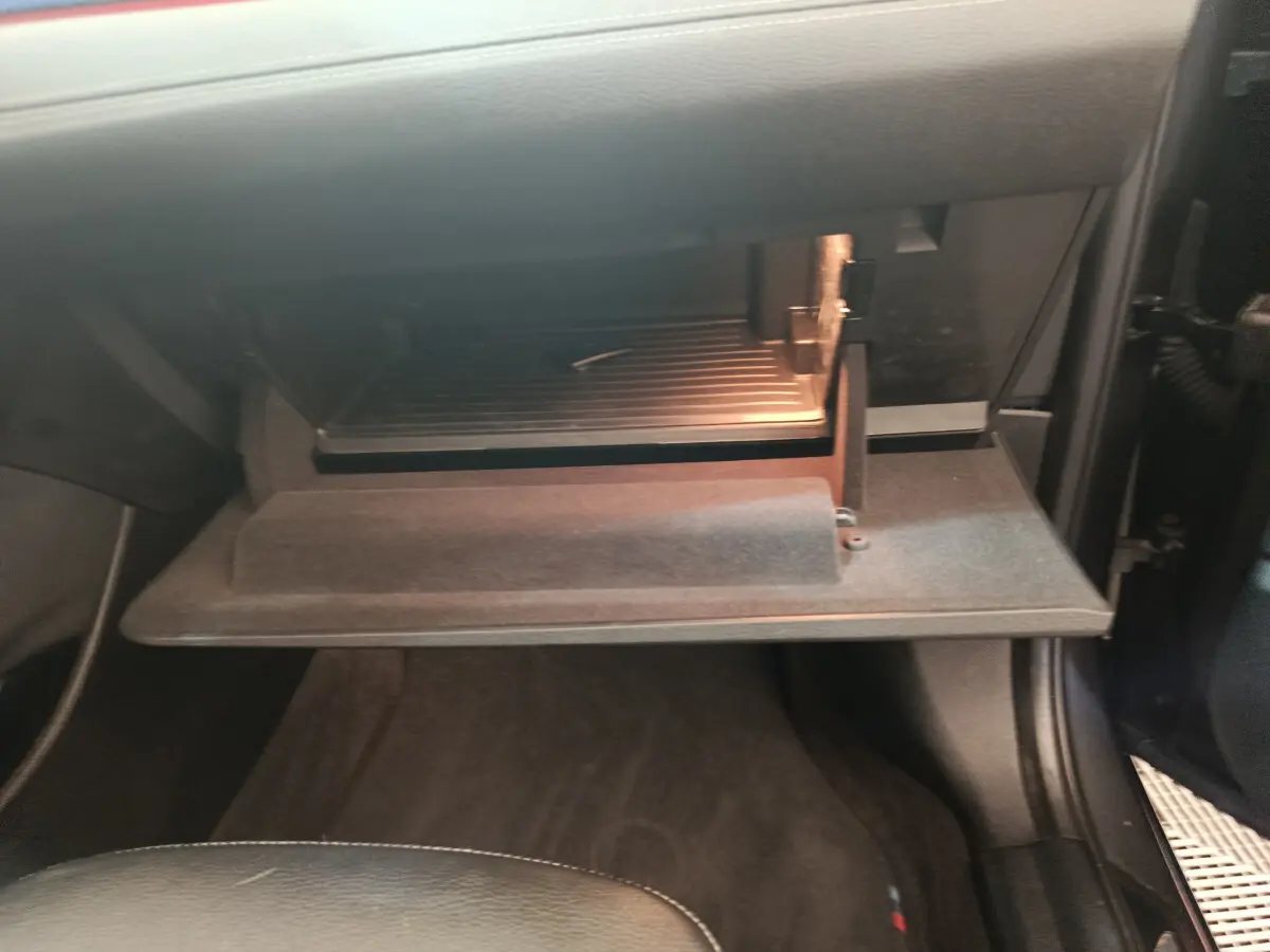 Gant de boîte à gants ouvert côté passager dans l'habitacle sombre d'un BMW X1 sDrive18i M Sport 2019