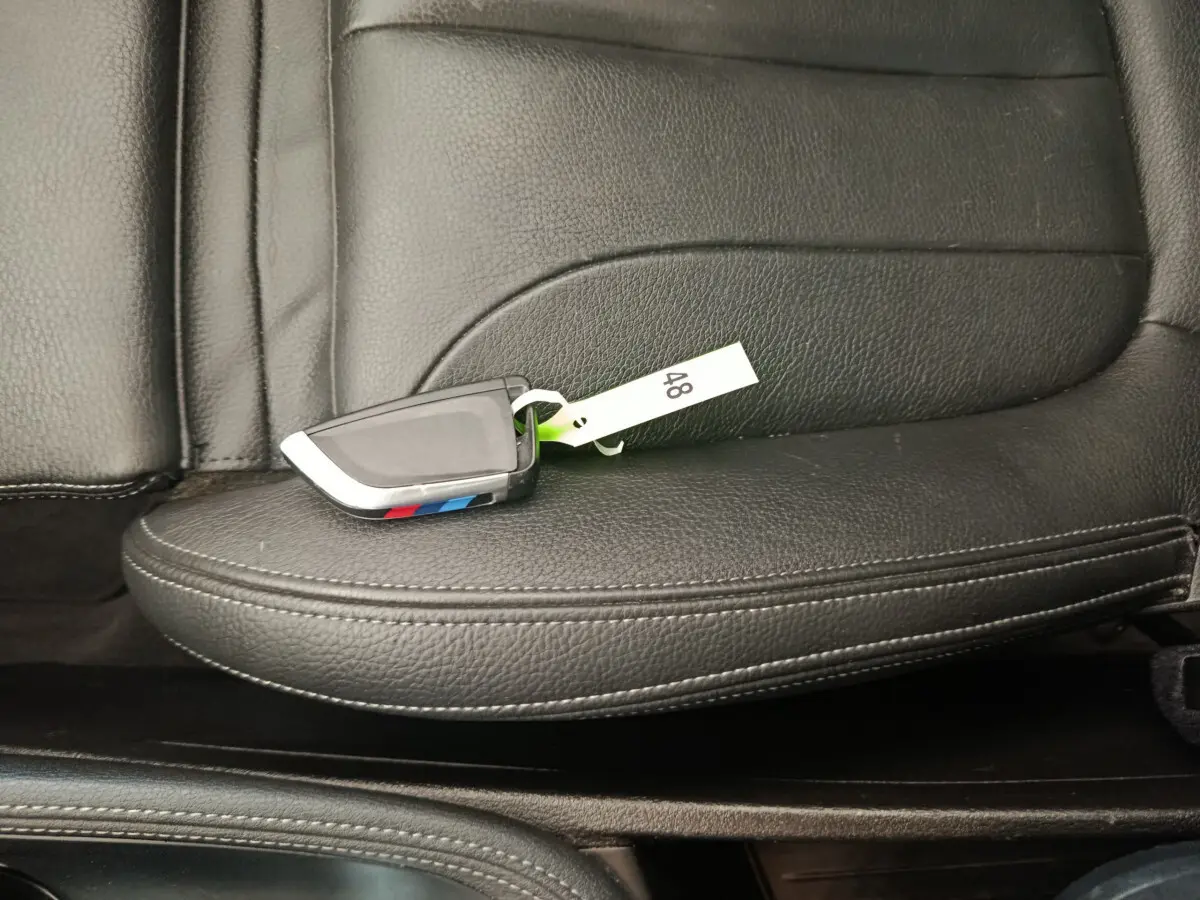 Clé BMW posée sur un siège en cuir noir à surpiqûres blanches, intérieur du BMW X1 sDrive18i M Sport 2019.