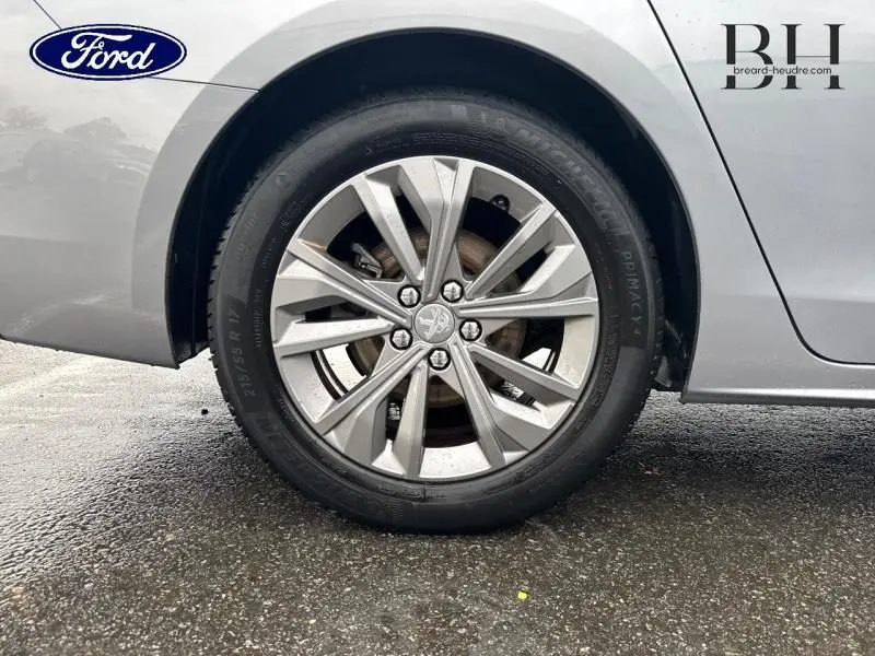 Gros plan sur la roue arrière droite gris Platinium d'une Peugeot 508 SW avec jante alu à dix branches.