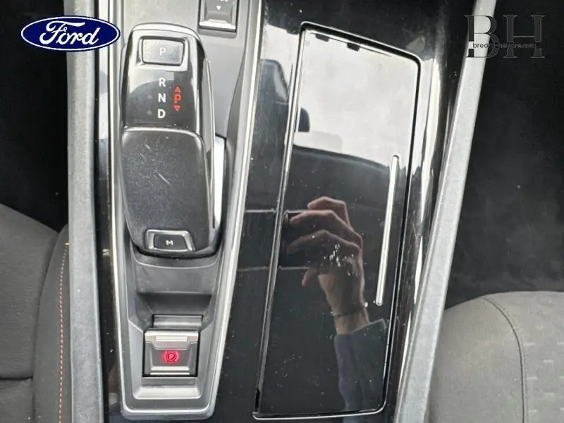 Gros plan sur la console centrale noire brillante de la Peugeot 508 SW gris Platinium avec levier de vitesse automatique et frein électrique.