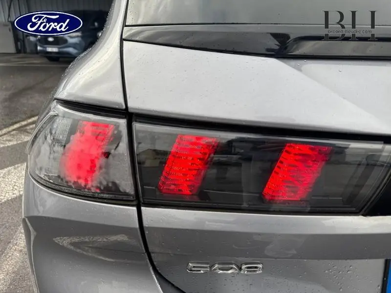 Gros plan sur le feu arrière droit rouge d'une Peugeot 508 SW gris Platinium avec logo 508 visible sur le hayon.