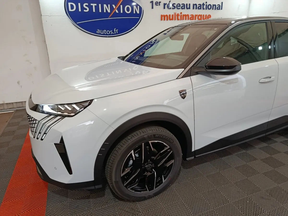 Vue 3/4 avant gauche d'un Peugeot 3008 blanc avec jantes noires et phares LED distinctifs.