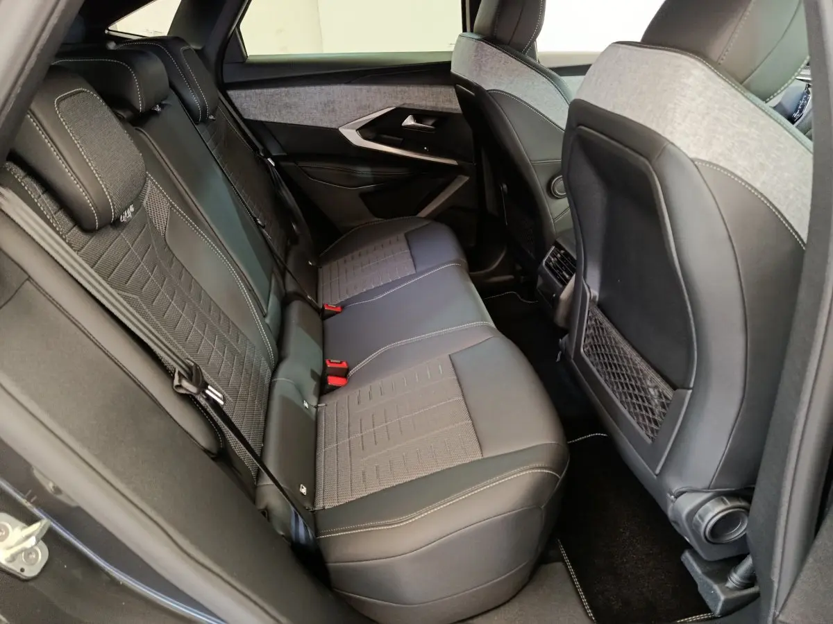 Vue intérieure côté gauche des sièges arrière en tissu gris et cuir noir du Peugeot 3008 1.2 HYBRID 145 E-DCS6 GT 2025.