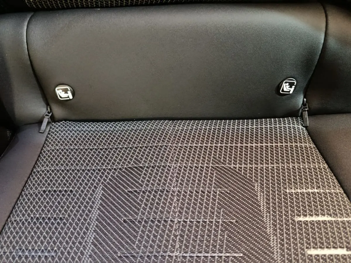 Gros plan sur la banquette arrière noire du Peugeot 3008 hybride 2025 avec fixation Isofix visible.