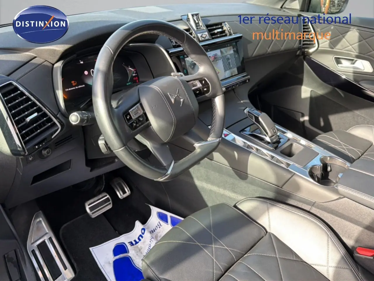 Vue intérieure côté conducteur du DS7 2024 noir perle, mettant en valeur le volant cuir et la console centrale moderne.