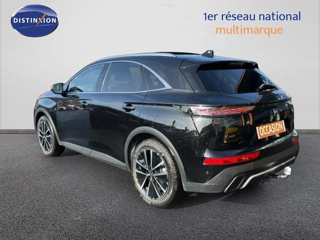 Vue 3/4 arrière droite d'un DS7 1.5 BlueHDi 130 noir perle avec jantes alliage et attelage visible.