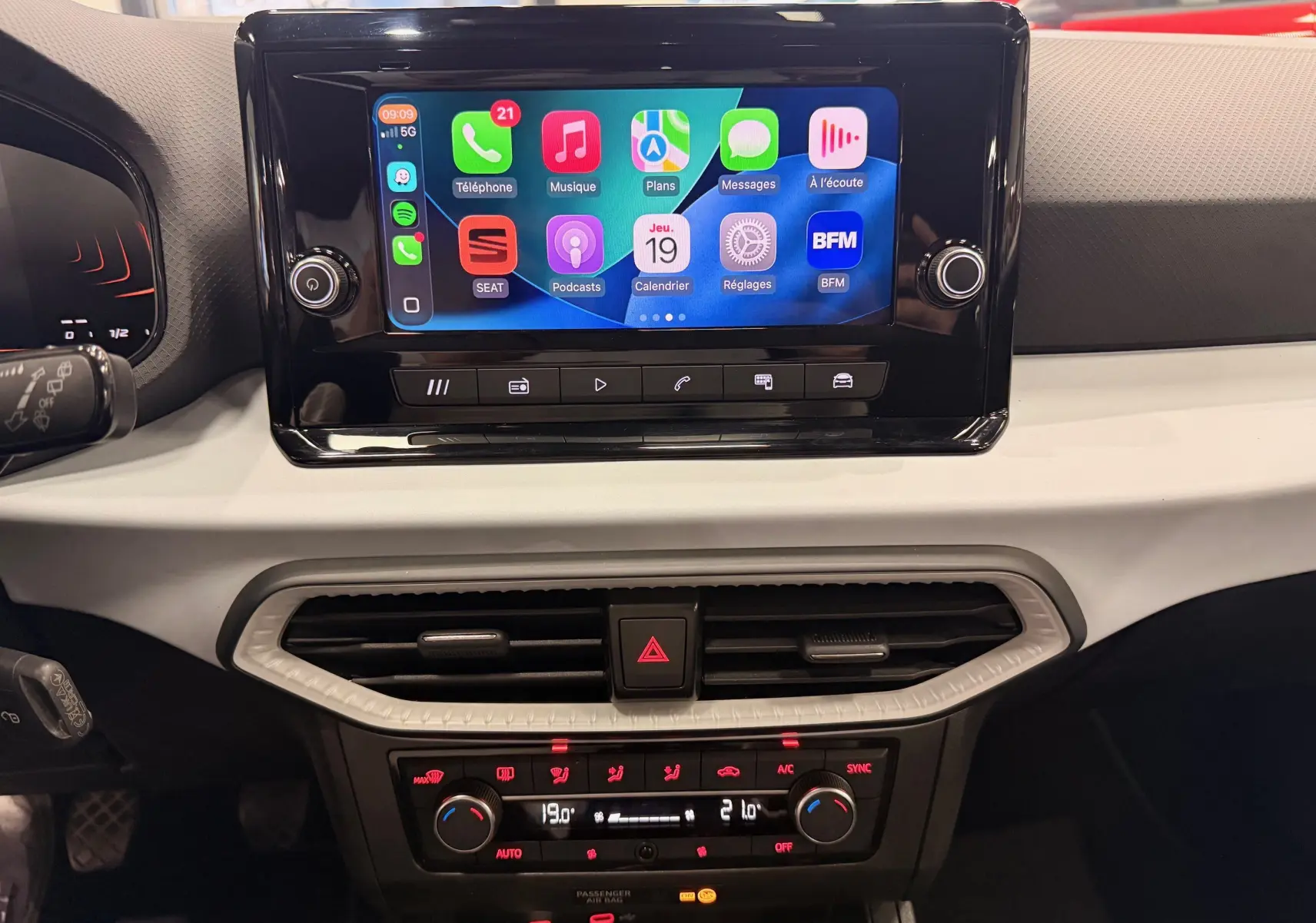 Vue rapprochée de la console centrale de la SEAT Ibiza 2025, écran tactile avec interface connectée et commandes climatiques.