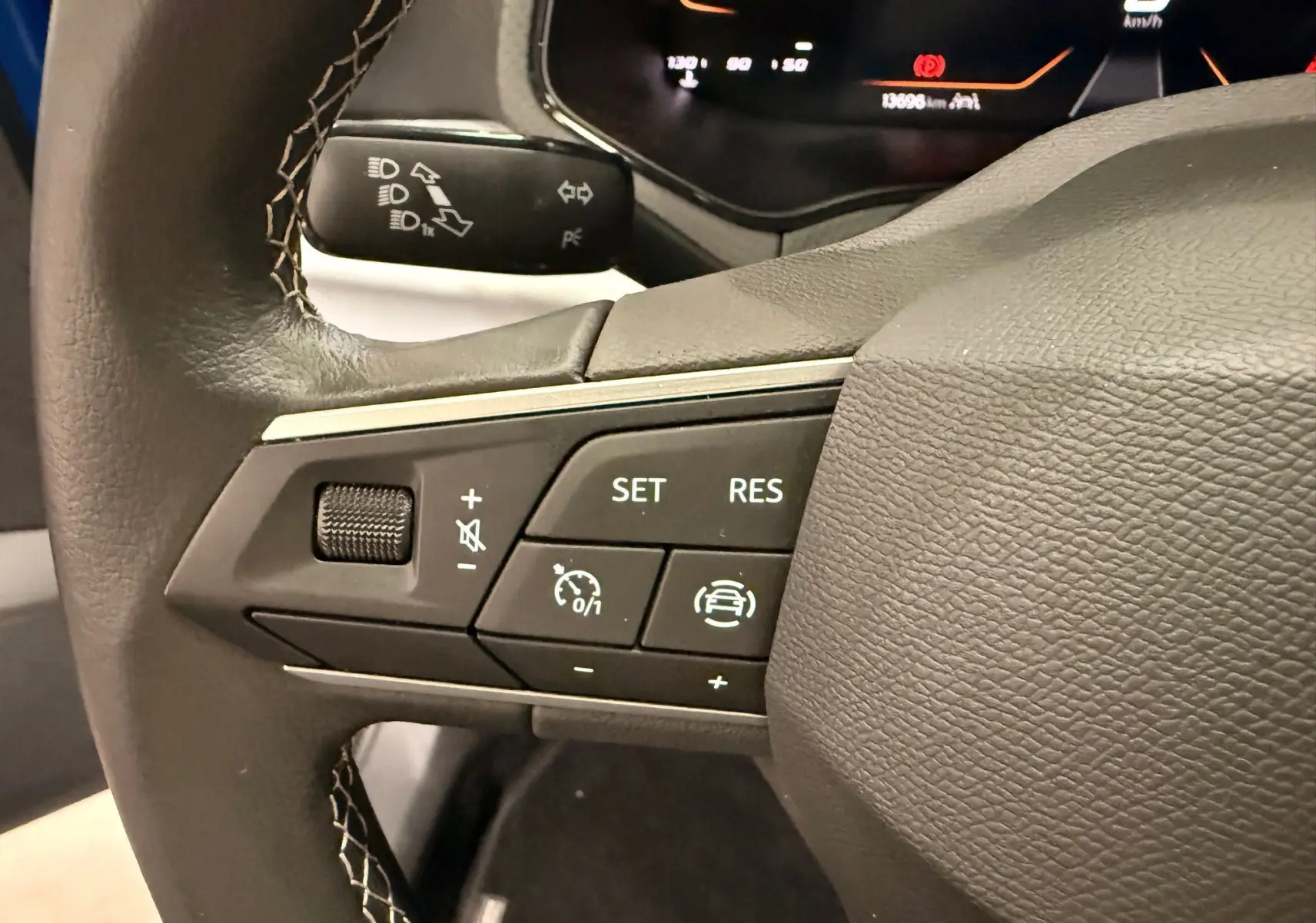 Gros plan sur les commandes au volant du SEAT Ibiza 2025, version 1.0 TSI Copa, avec tableau de bord numérique en arrière-plan.