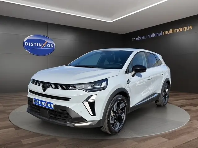 Vue 3/4 avant d'un Renault Symbioz gris clair avec calandre noire et jantes noires brillantes dans un showroom.