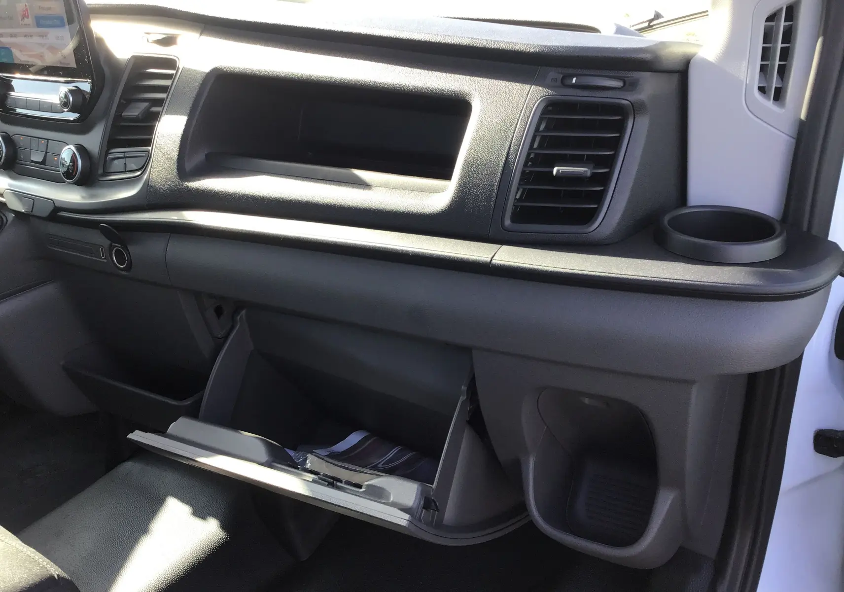 Intérieur côté passager du Ford Transit Chassis Cabine blanc 2020, tableau de bord avec boîte à gants ouverte et porte-gobelet.