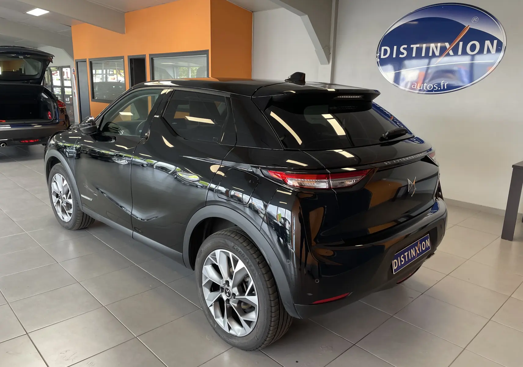 Vue 3/4 arrière droite du DS3 Crossback Perla Nera 2024, avec jantes alu 18 pouces et vitres surteintées en showroom.