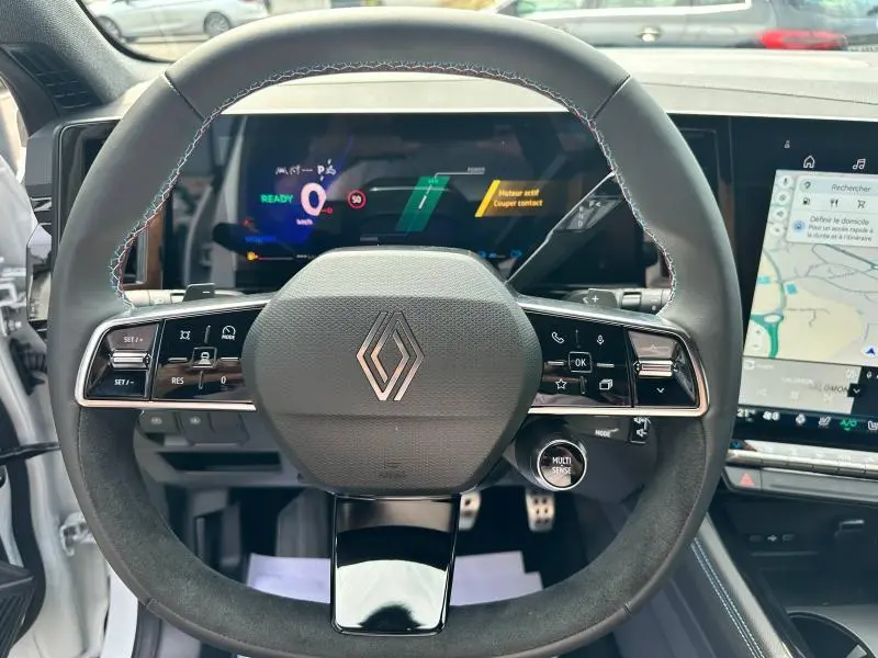 Vue intérieure centrée sur le volant noir du Renault Austral 2025 avec tableau de bord numérique et écran tactile GPS.