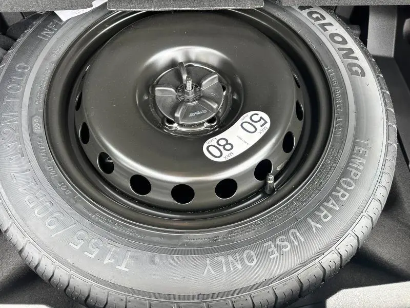 Gros plan sur la roue de secours noire temporaire du coffre du Renault Austral gris 2025 esprit Alpine.