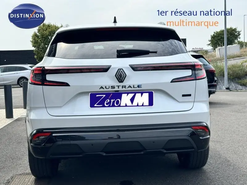 Vue arrière du Renault Austral gris avec feux LED horizontaux et logo central visible sur un parking extérieur.