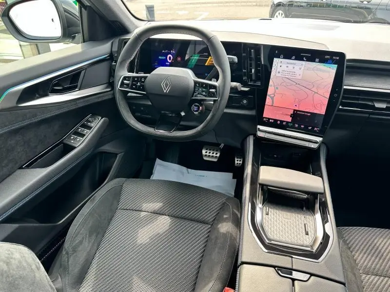 Vue intérieure côté conducteur du Renault Austral gris 2025 avec volant multifonction et grand écran tactile central.